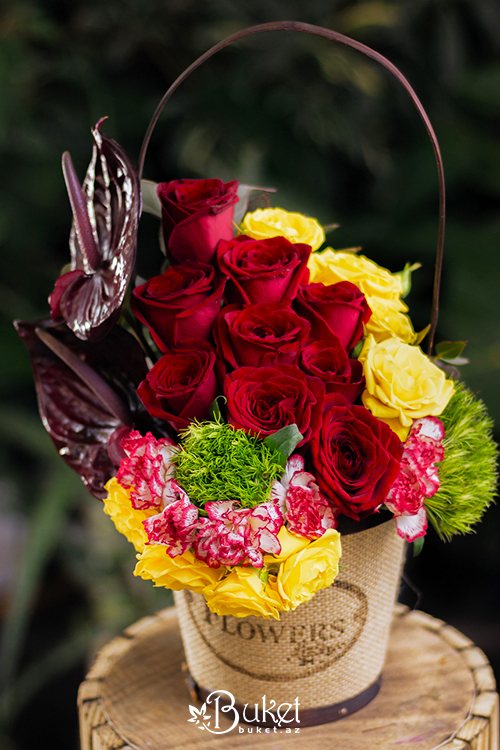 Composition in a basket of anthurium and yellow roses